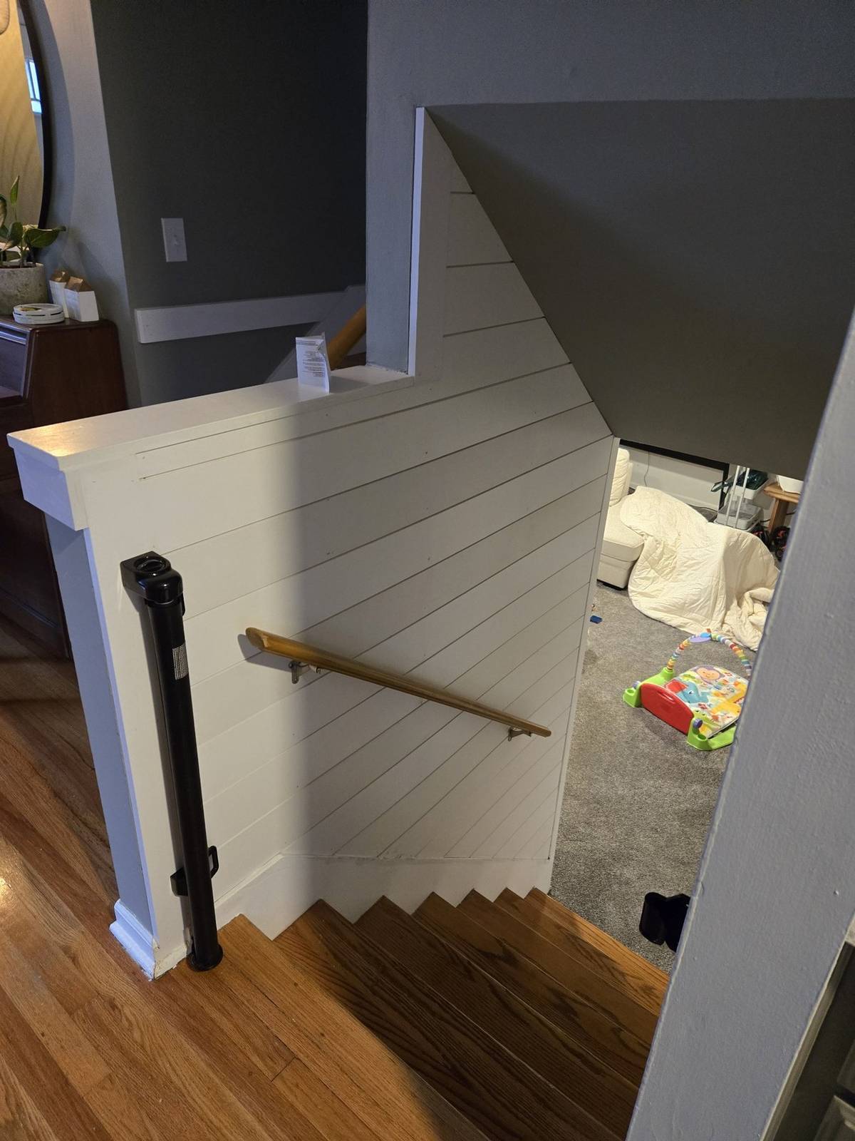 Finished shiplap wall and railing beside a staircase
