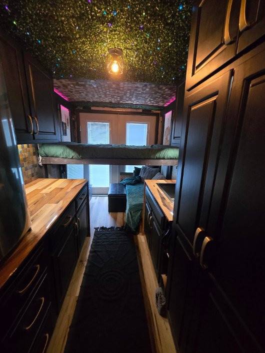 Trailer galley with butcher-block counters, storage and a sleeping loft